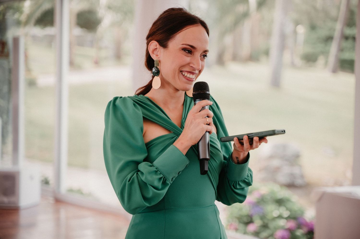 A photographer in a green top taking pictures during a wedding event.