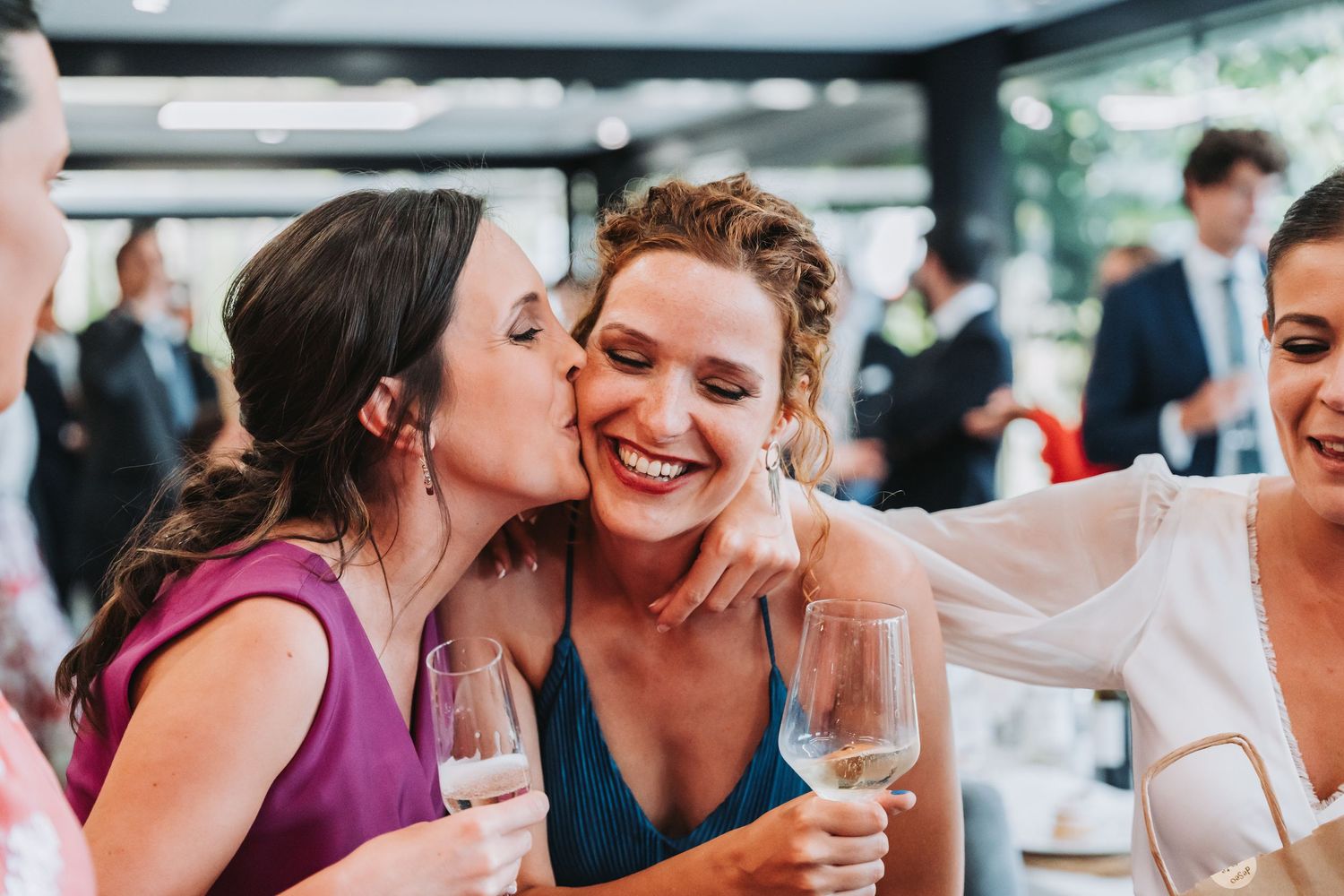 Guests laugh and share intimate moments during a lively wedding reception party.