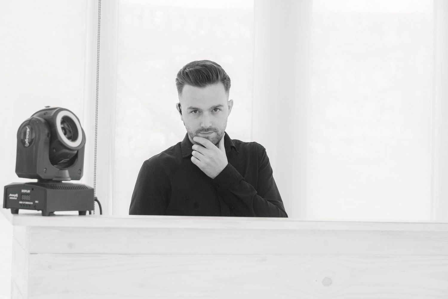 Black and white panoramic photo showing a modern interior space with artistic lighting.