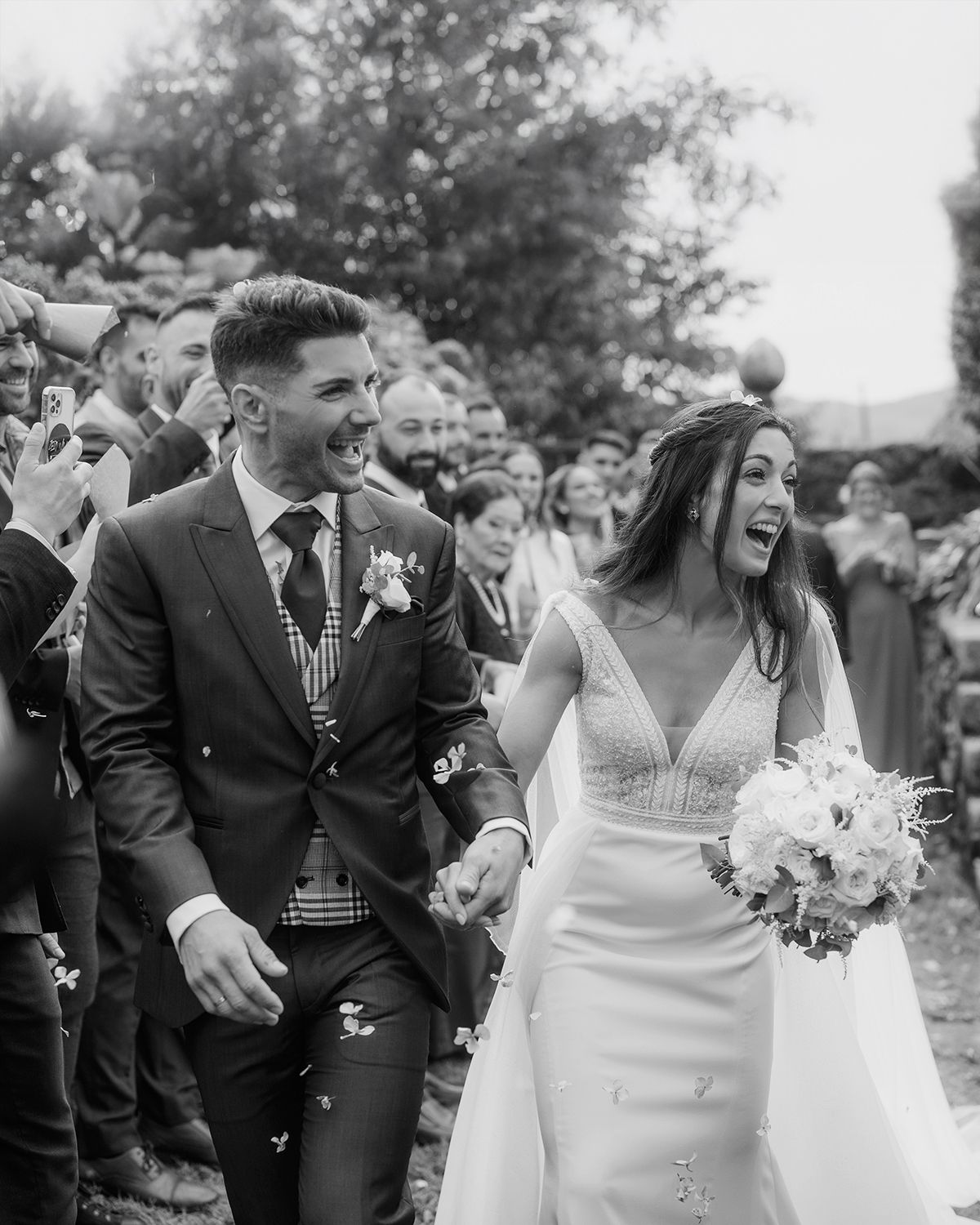 A joyful wedding celebration with confetti flying as newlyweds walk down the aisle together.Wedding photographer Spain. Galicia.