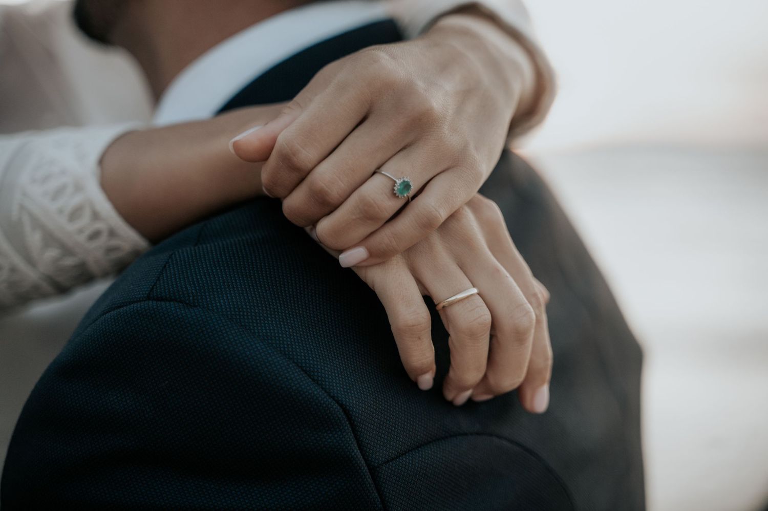 Close-up of hands with wedding rings showing intimate moment between couple.
