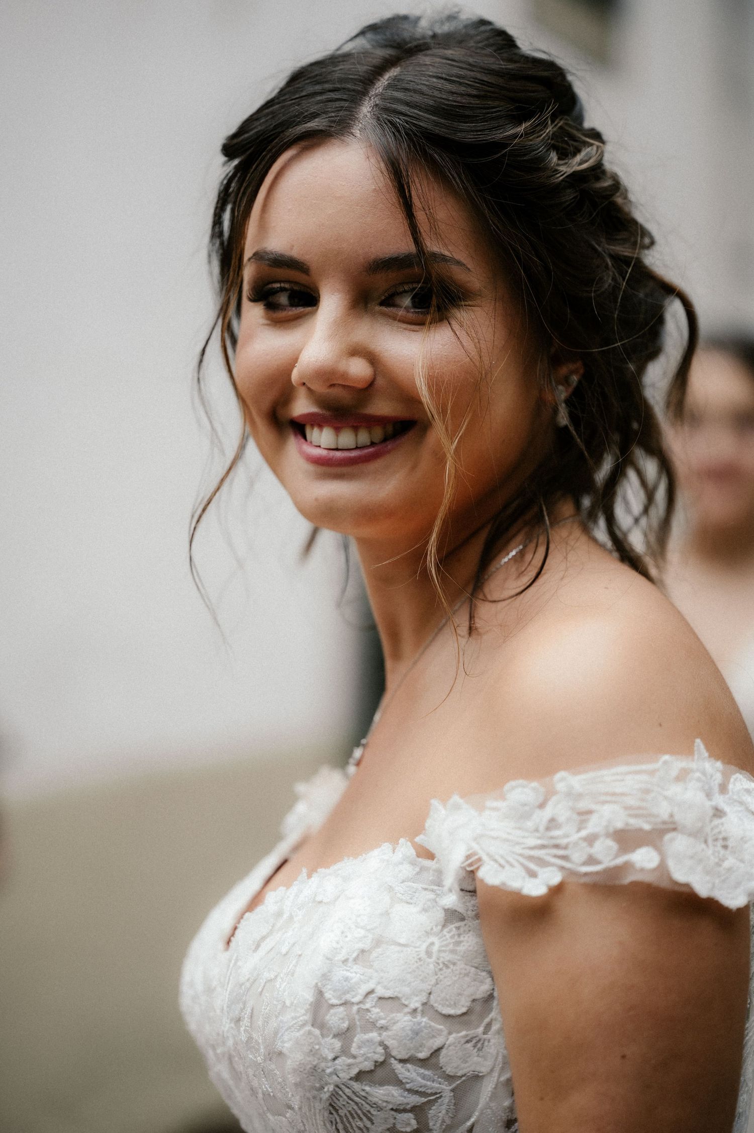 Close-up shots of an elegant bridal look featuring an off-shoulder lace wedding gown and upswept hairstyle.