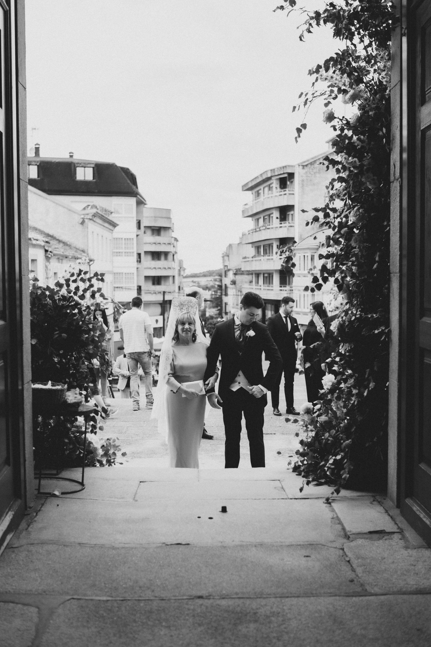 Black and white photo series showing a couple walking down a street in what appears to be a vintage wedding scene.