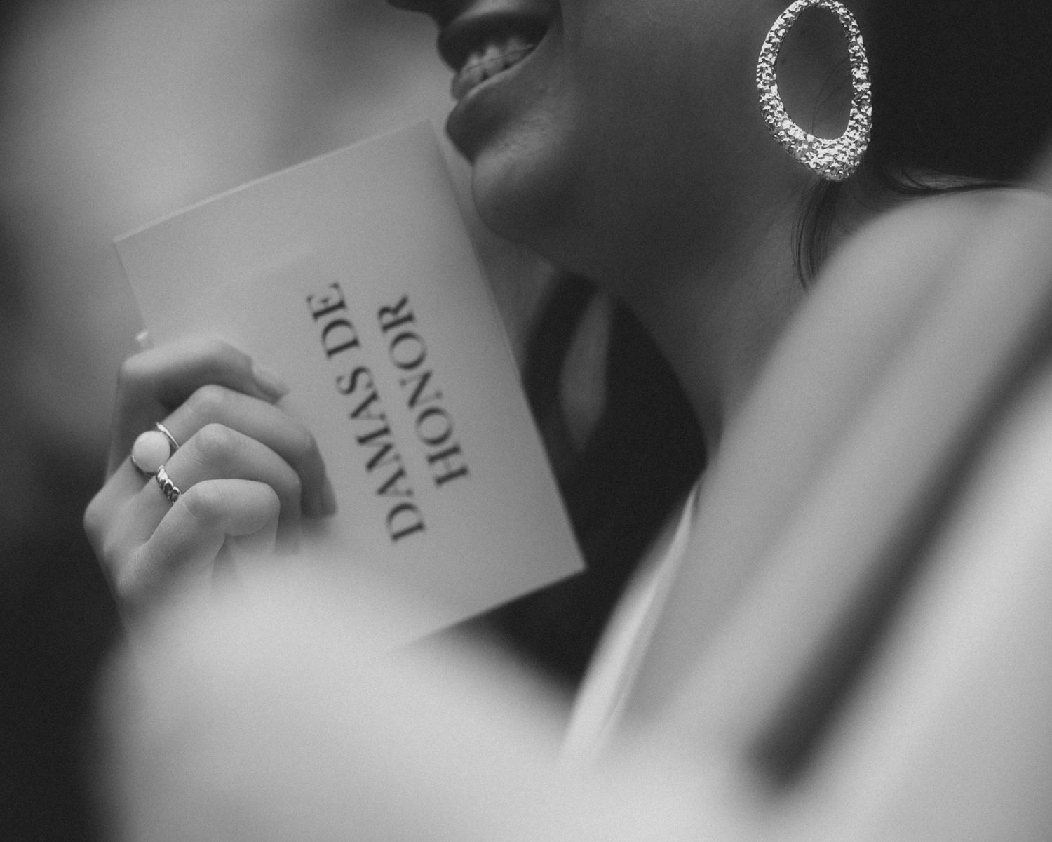 Close-up black and white detail shot of wedding rings and stationery.