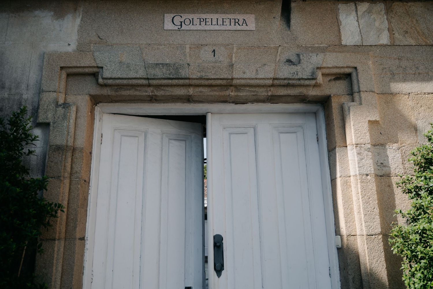 Stone building entrance with white doors and 'Gourmedia' signage above.