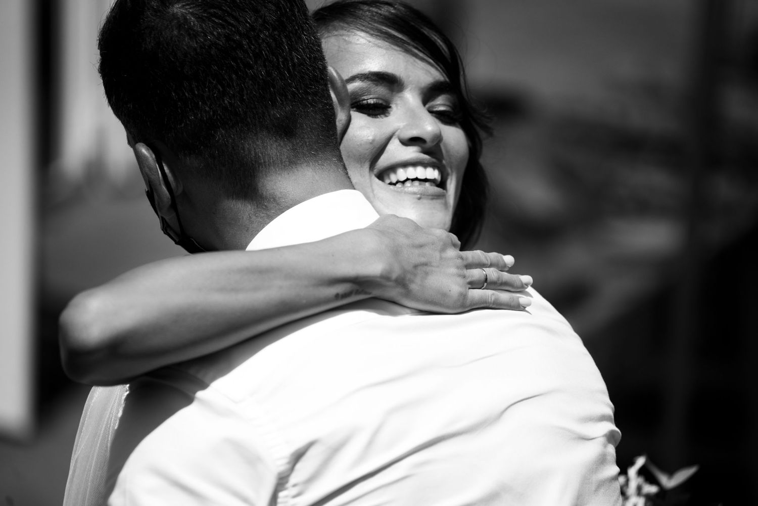 A series of black and white photographs showing joyful embraces and celebrations at a wedding event.