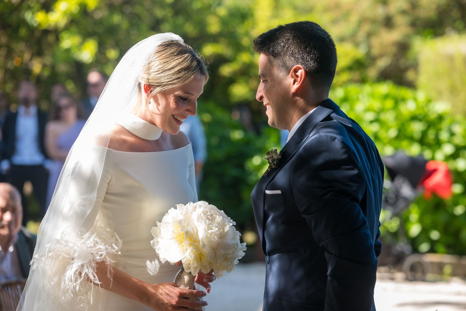 A couple shares a romantic moment during their outdoor garden wedding ceremony.