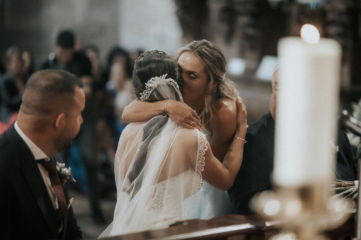 Wedding ceremony captured in soft focus with white candles and romantic lighting creating an intimate atmosphere.