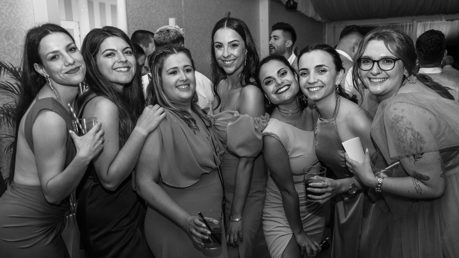 A black and white photo of a group of friends celebrating and posing together at a party.