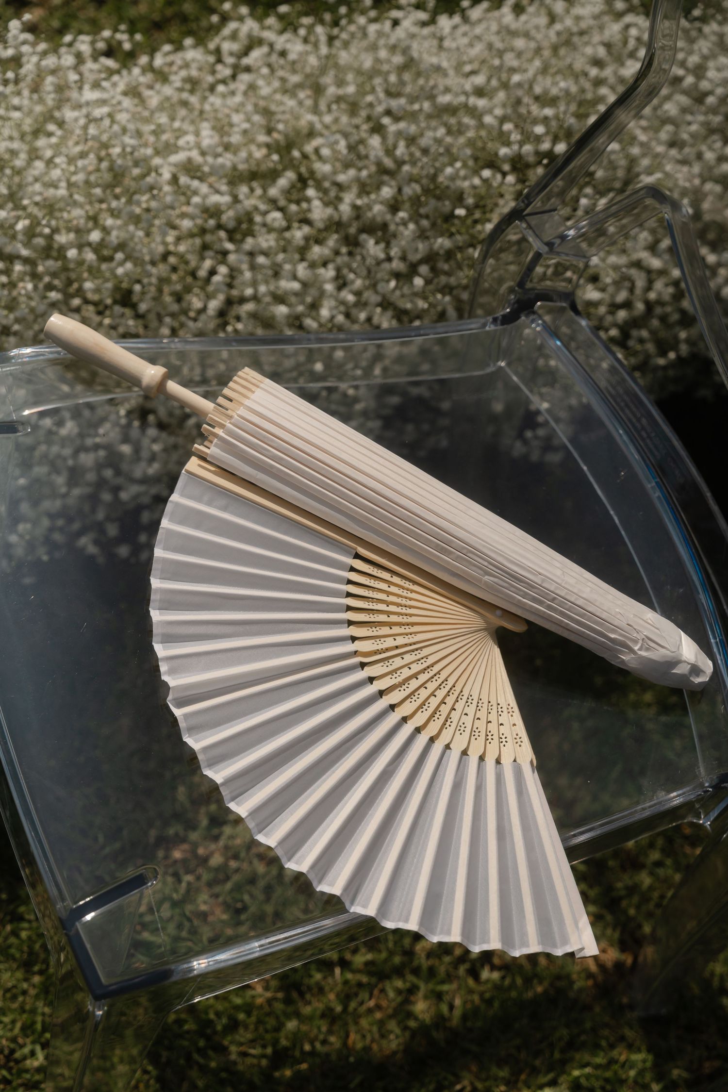 White paper hand fans arranged in a sequence showing different angles on a dark surface.