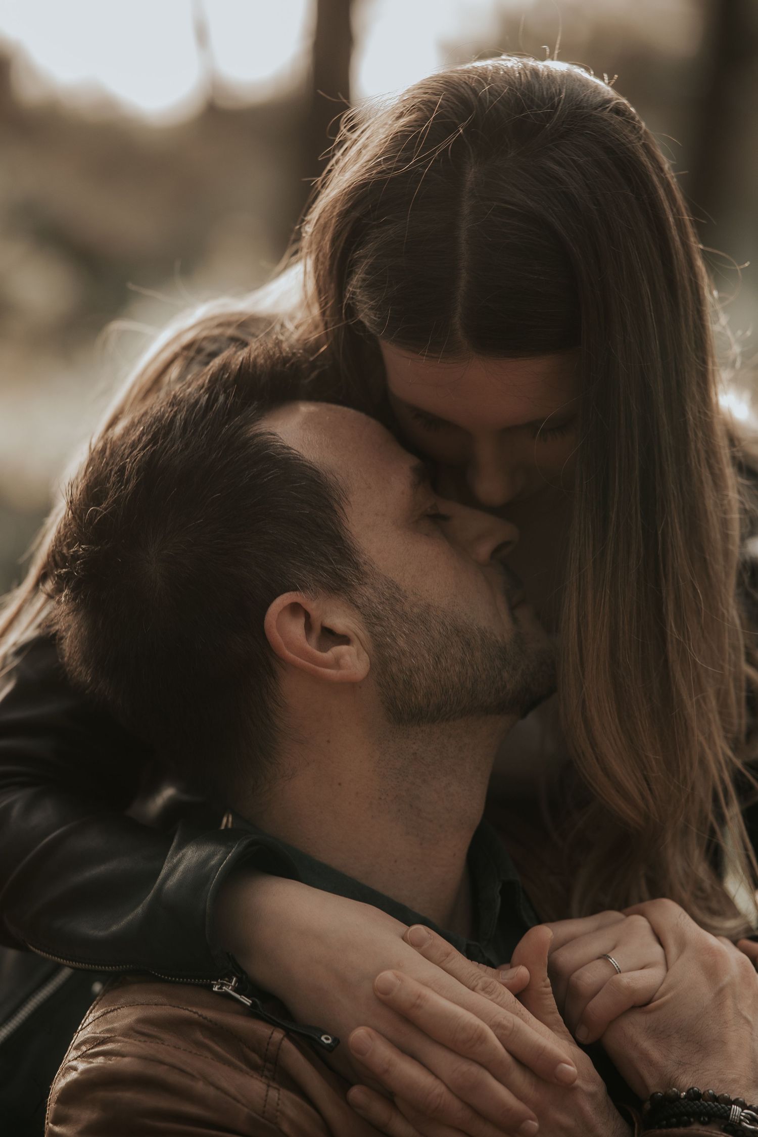 Romantic couple sharing intimate kisses in a series of close-up sepia-toned photographs.