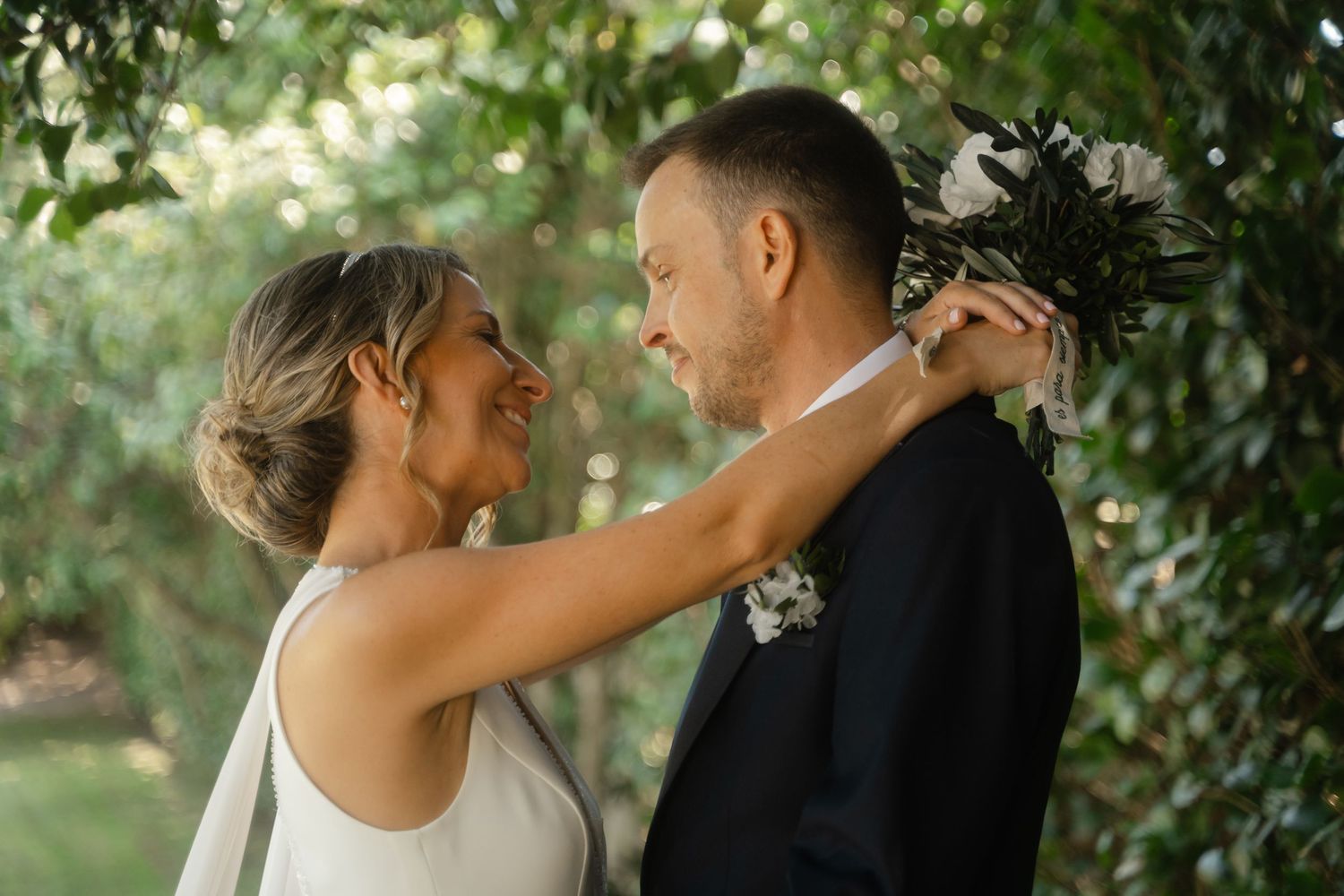 A couple shares intimate moments in a romantic outdoor photoshoot surrounded by lush greenery.