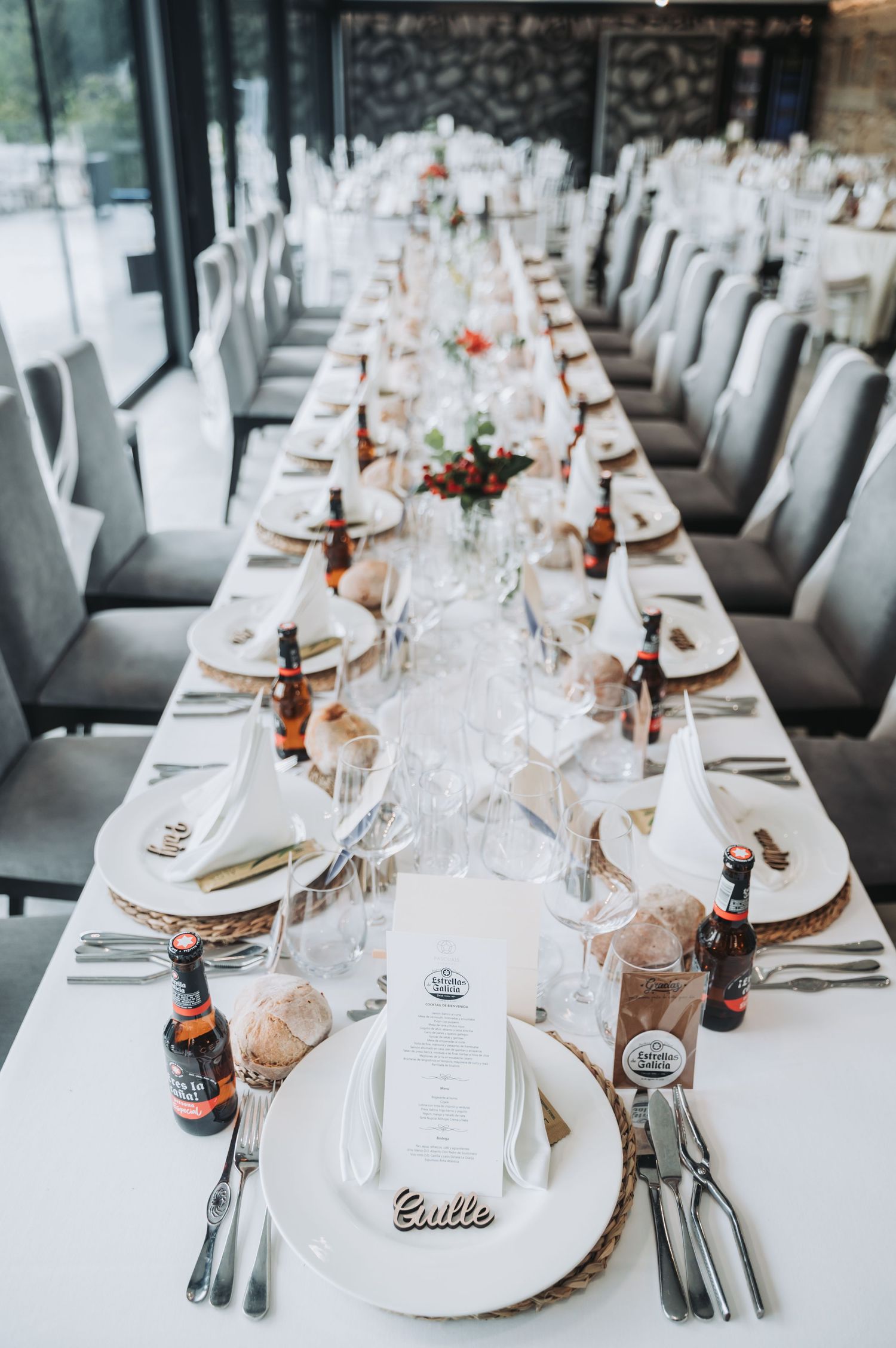 Elegant wedding reception tables set with white linens, copper accents, and place settings in a modern venue.