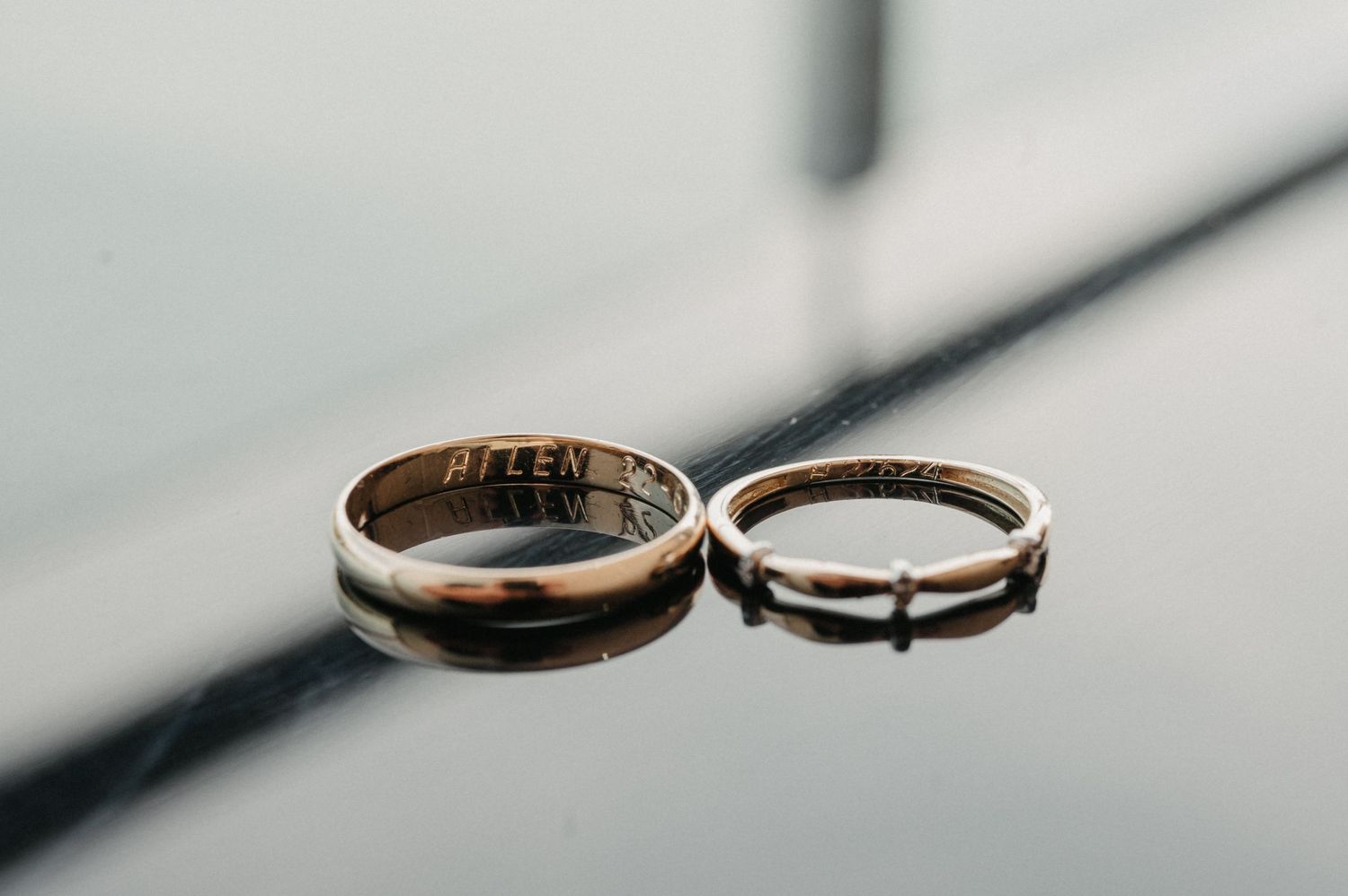 Close-up of two gold wedding rings resting on a textured surface with soft focus.