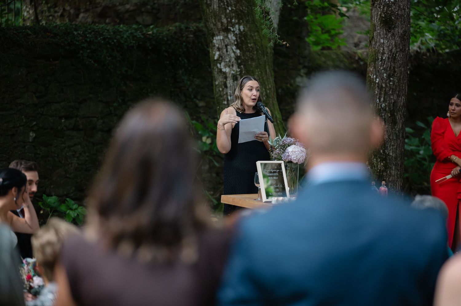 Outdoor wedding ceremony taking place in a serene woodland setting.