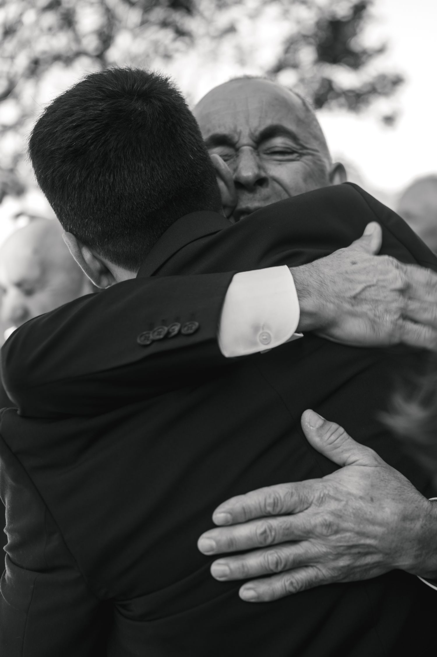 Black and white photo series showing a warm embrace between two people, captured in intimate close-up shots.