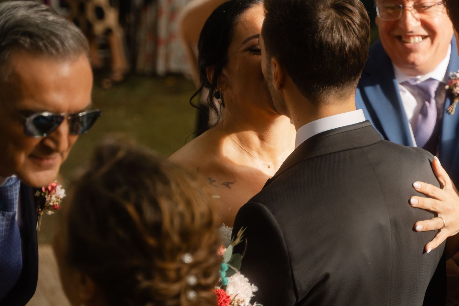 Wedding guests gathered together in formal attire during an outdoor celebration.