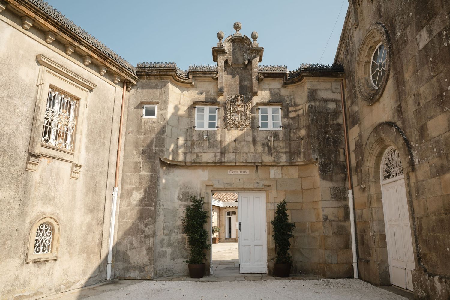 Ancient stone courtyard with arched windows and doorways in a historic European building complex.