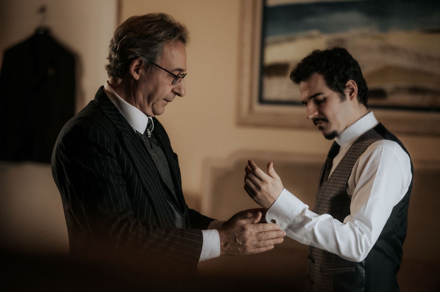 A series of candid black and white photos showing two men in formal attire having an animated conversation.