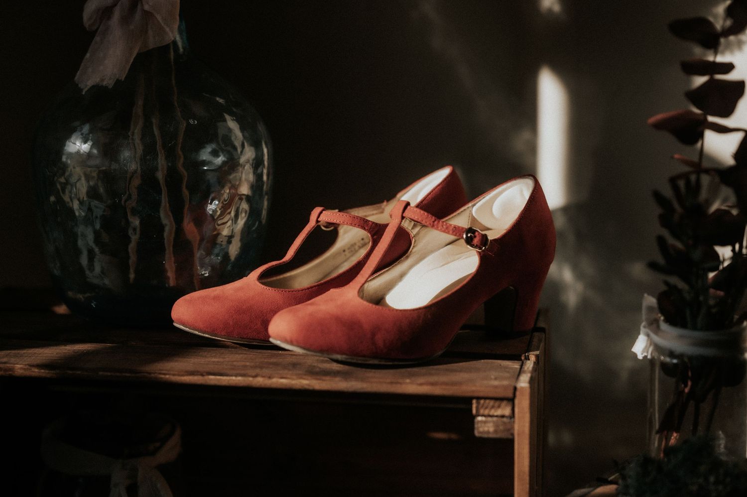 Vintage brown leather shoes arranged in a moody, dark setting with dramatic lighting.
