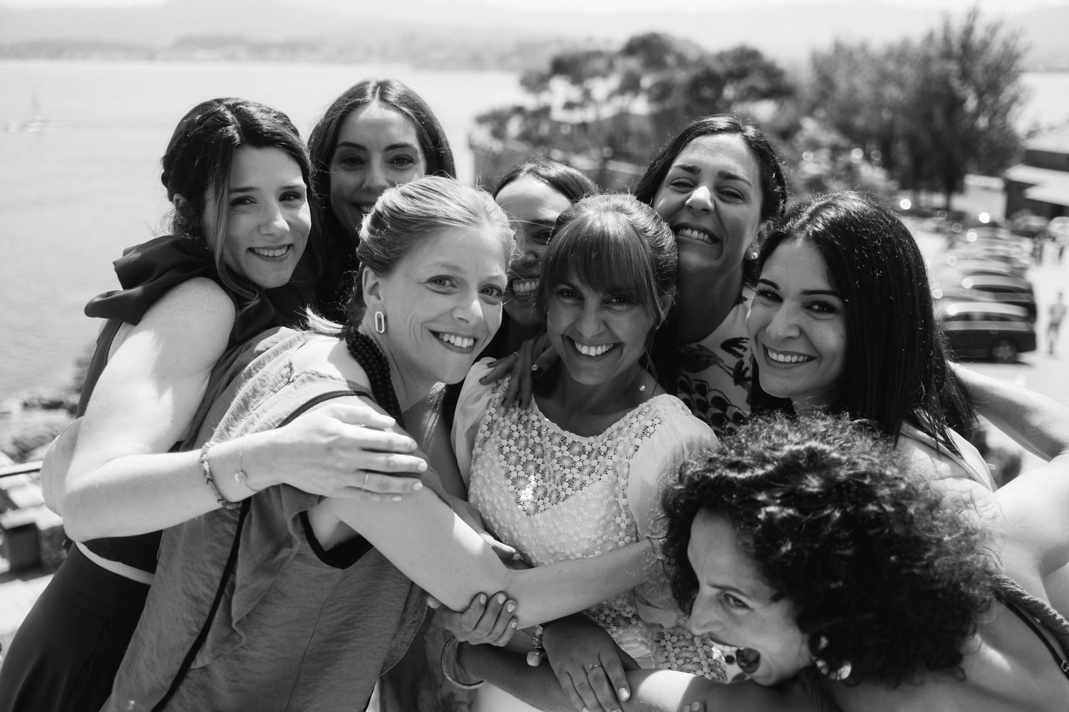 A series of black and white photographs showing joyful group embraces and candid moments of friendship.
