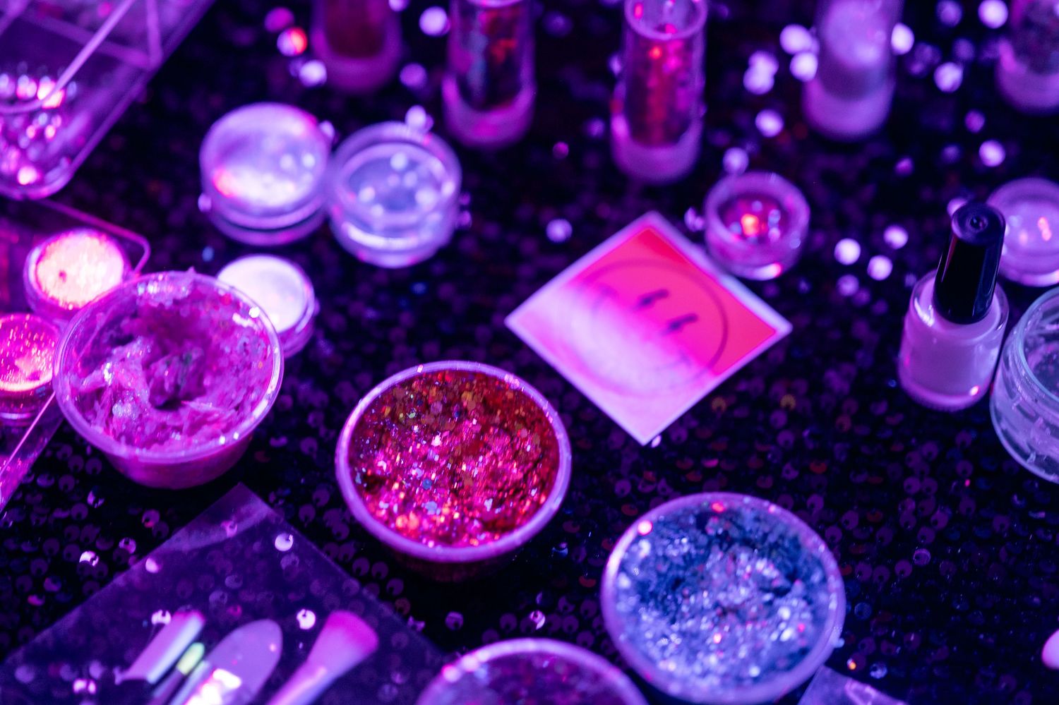 Colorful glitter and sparkly decorative elements under purple lighting.