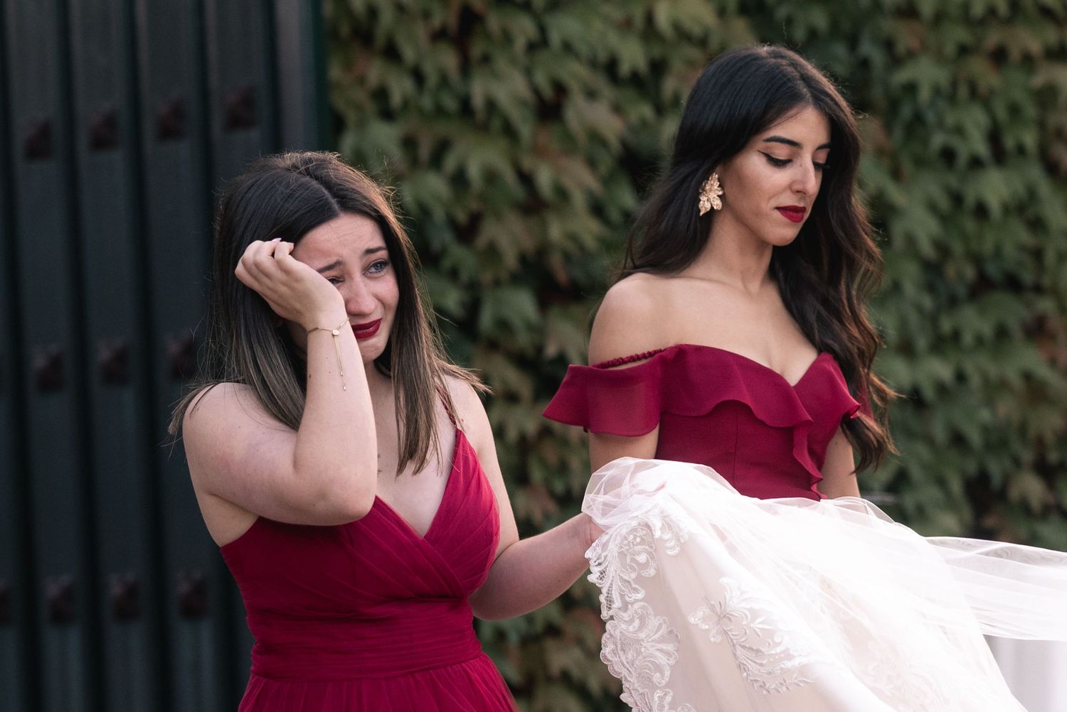 Two people in red and white formal attire share an intimate moment while dancing outdoors.