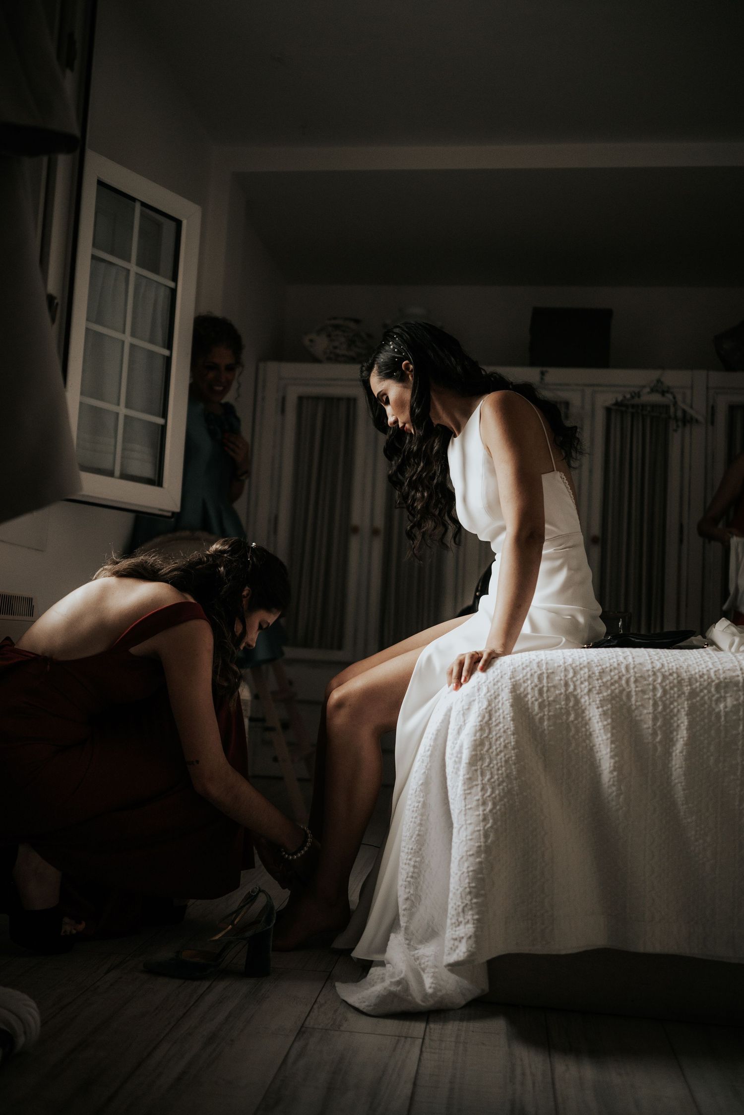 Moody boudoir photography capturing intimate moments in a sunlit room with white decor.