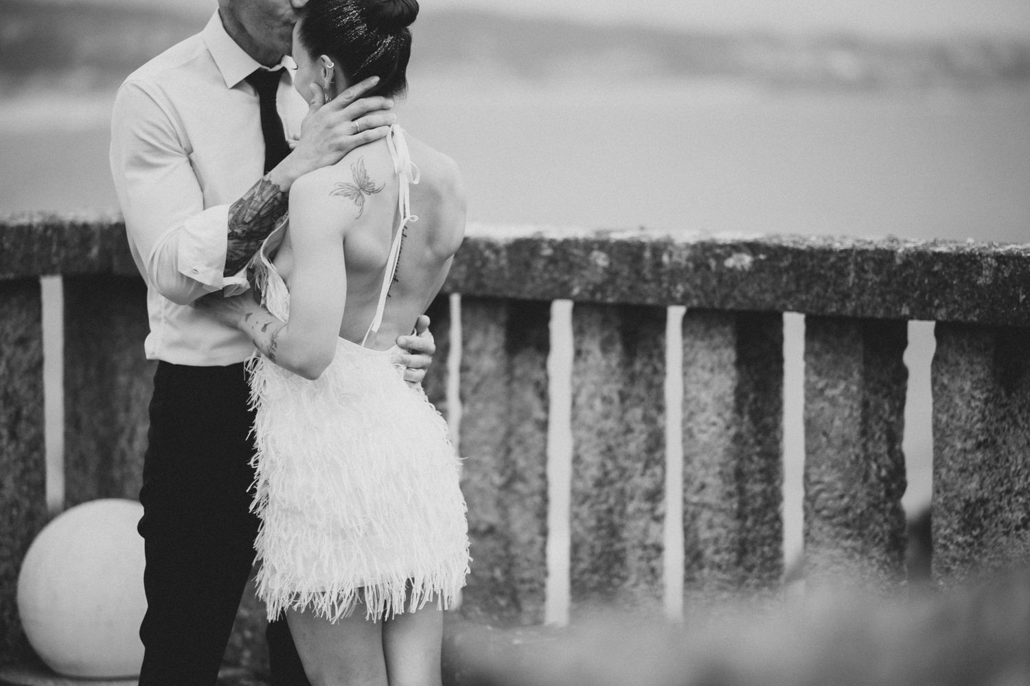 A couple shares an intimate moment during their first dance at an outdoor wedding reception.