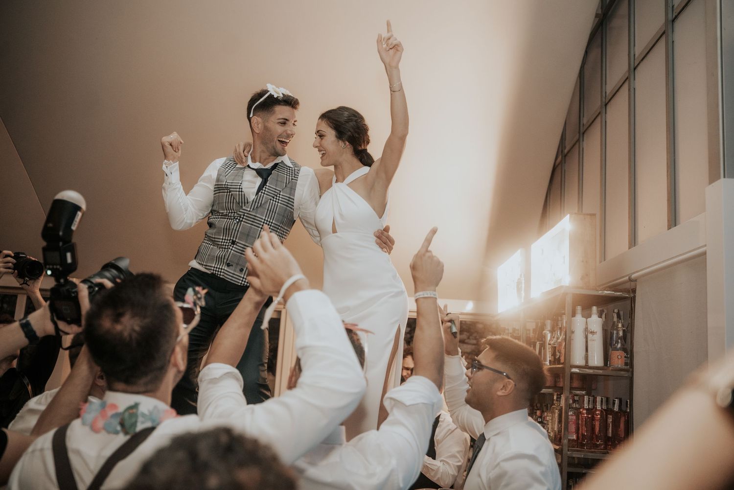 Wedding guests dancing and celebrating on a dance floor at a joyful reception party.