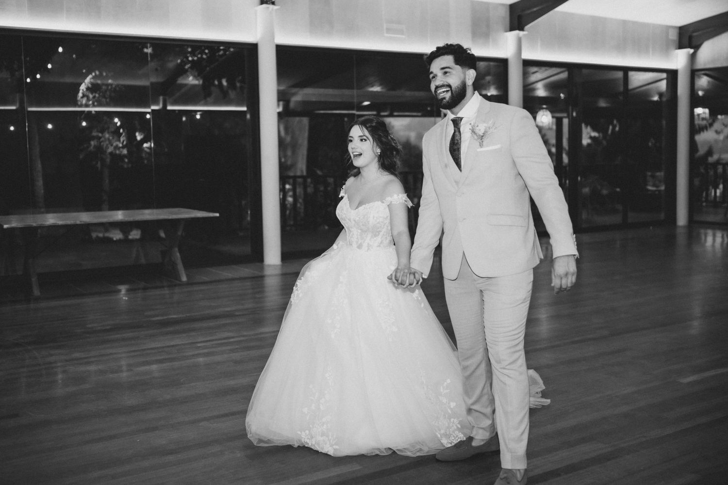 A couple in wedding attire dance together in an empty parking garage during a romantic photoshoot.