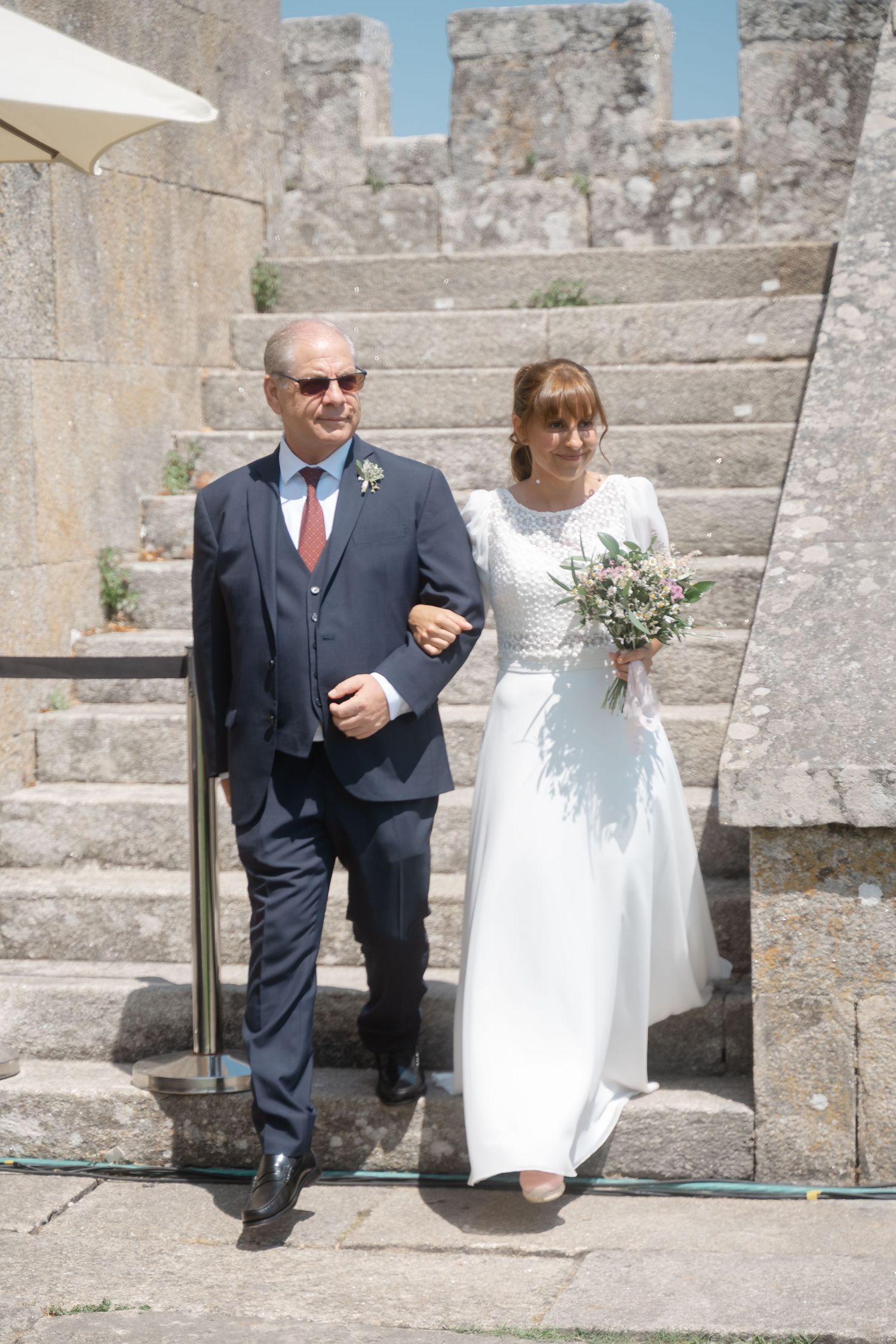 Stone steps and walls create a rustic backdrop for a wedding ceremony.