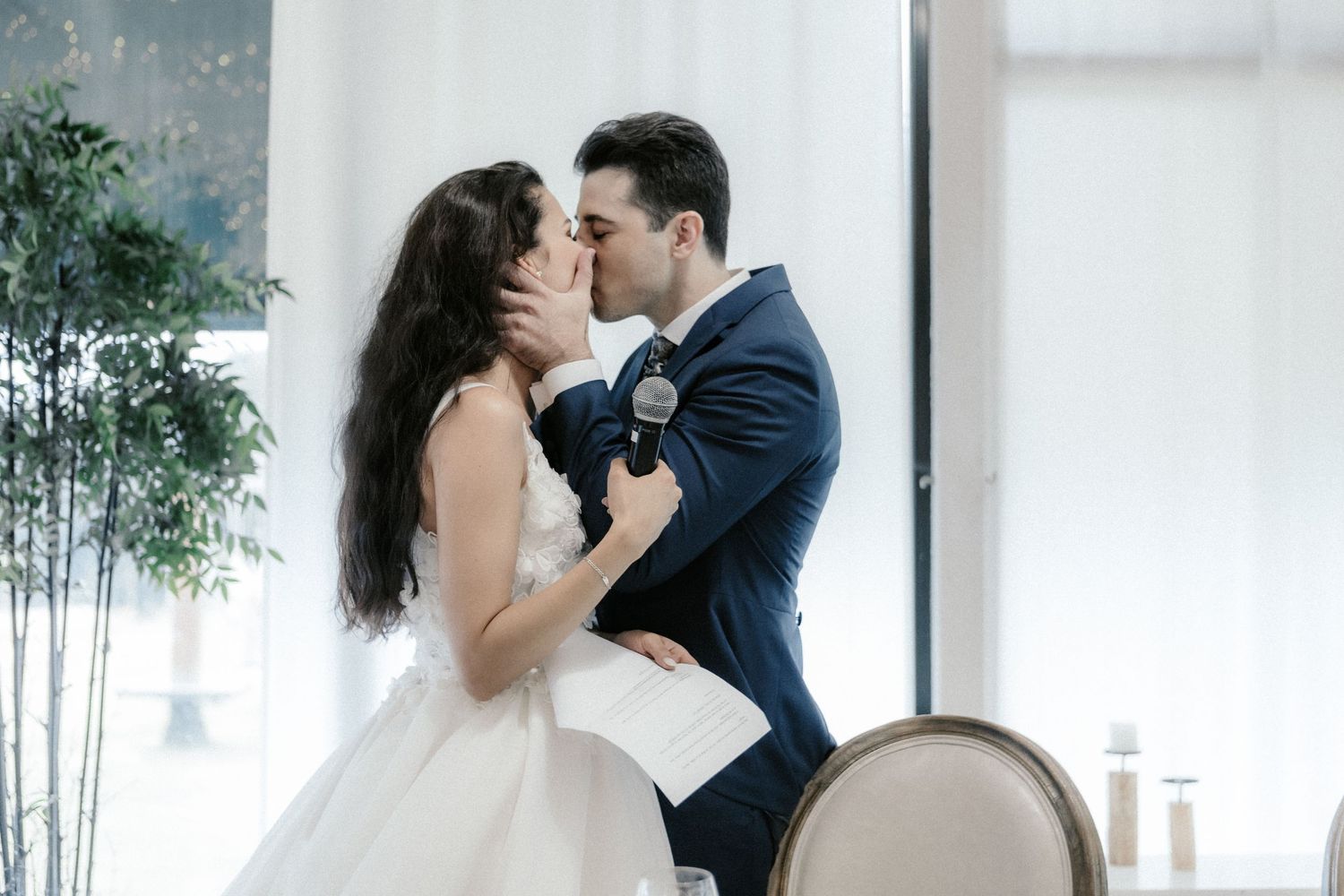 A romantic moment captured indoors as a couple in wedding attire share an intimate dance together.