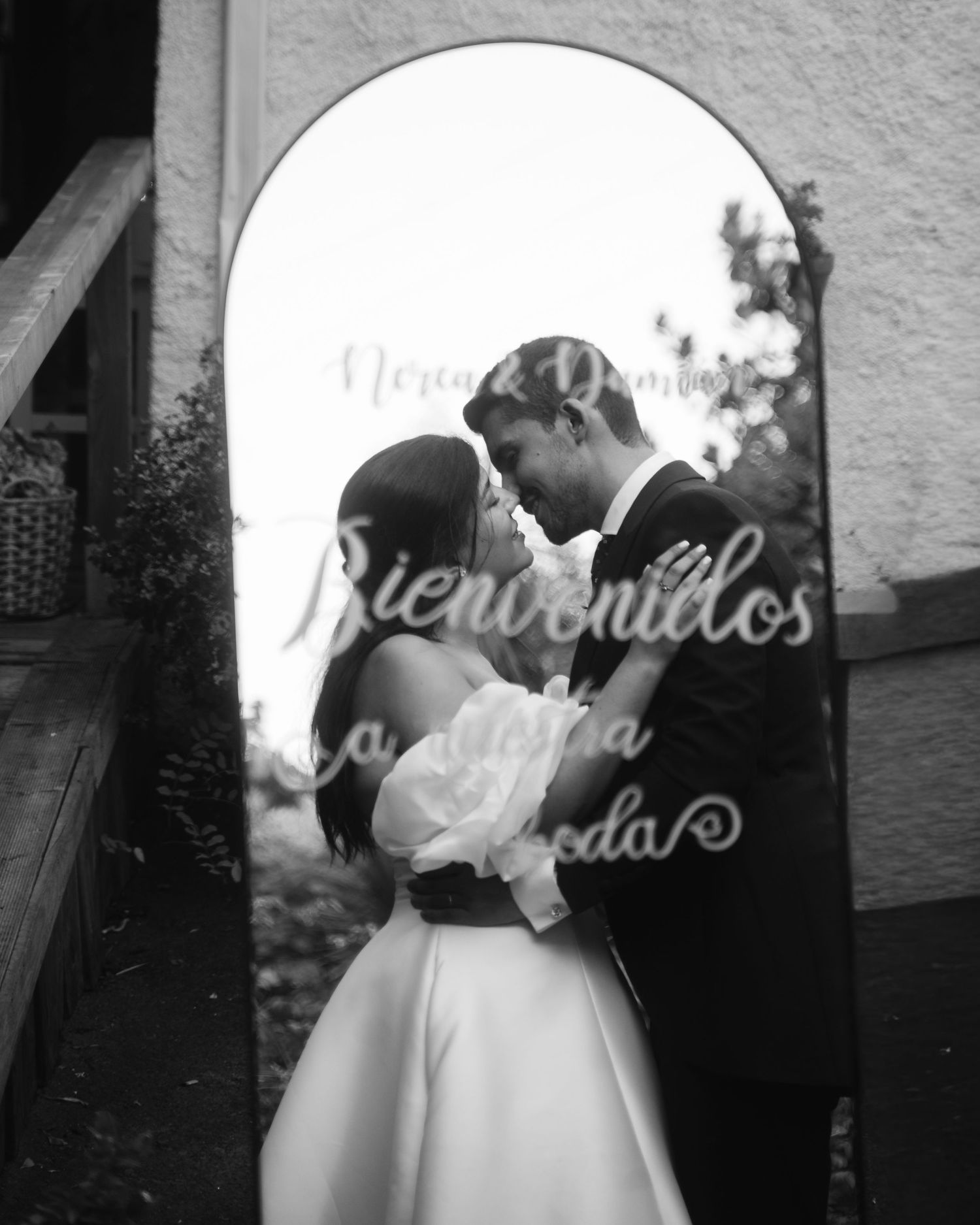 Black and white wedding photos showing romantic moments between newlyweds in an archway.