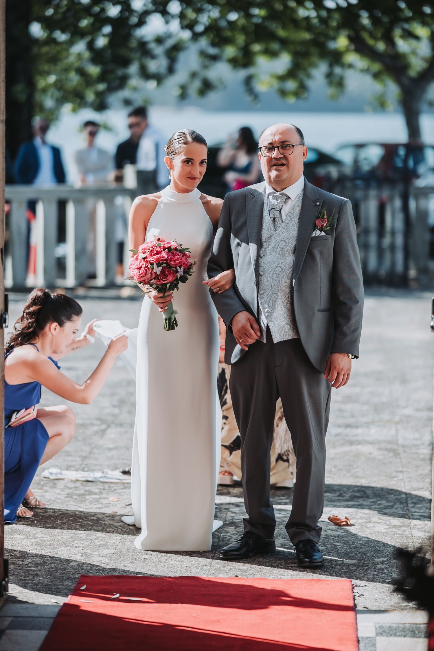 A sequence of wedding ceremony photos showing a couple at an outdoor waterfront venue with grey suits and red carpet.
