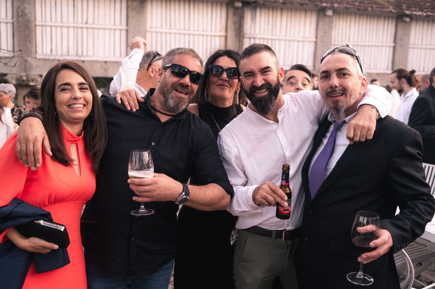 Wedding guests gather together for group photos at a reception celebration.