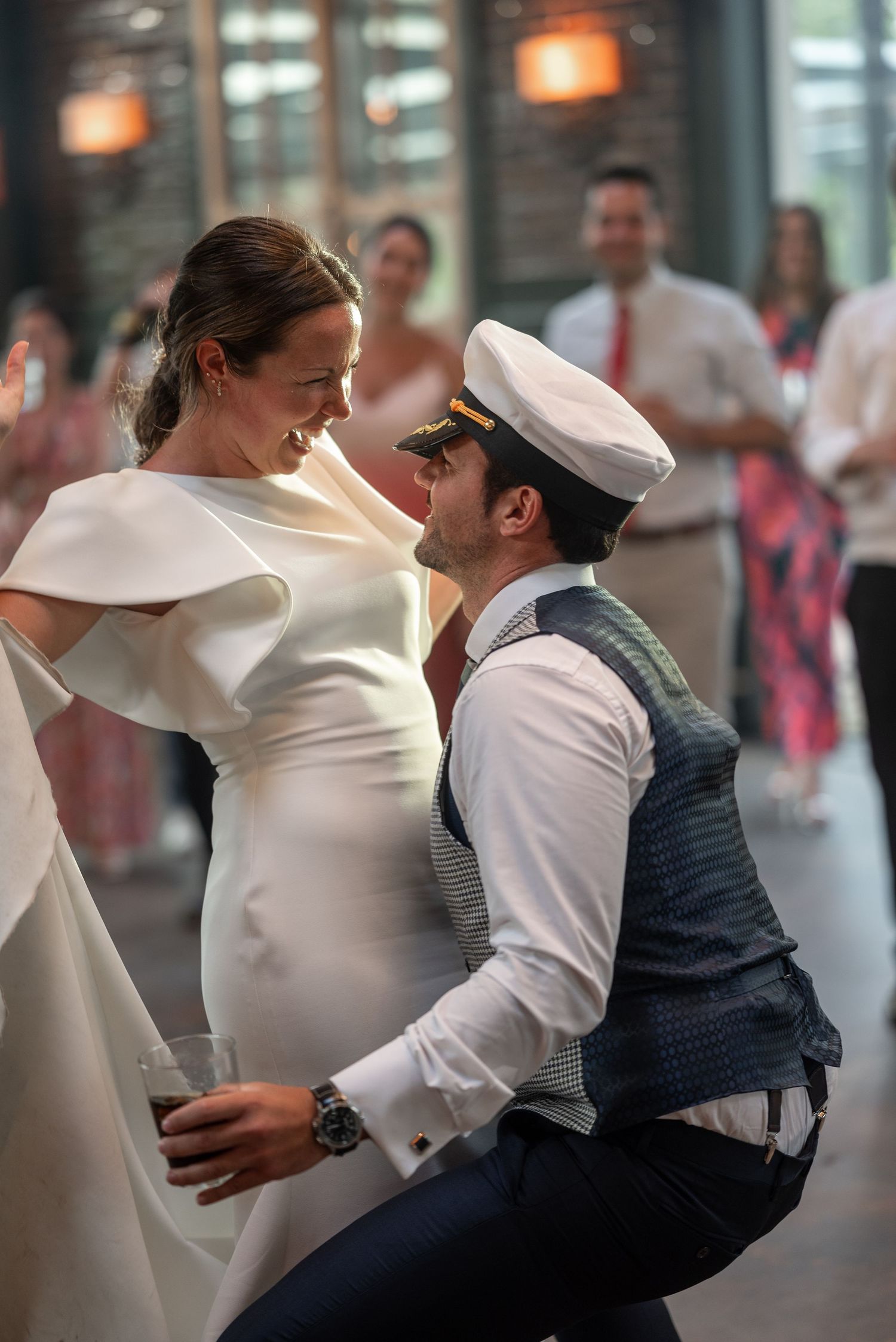 A couple in formal attire performs a dramatic dance move with a dip during a performance.