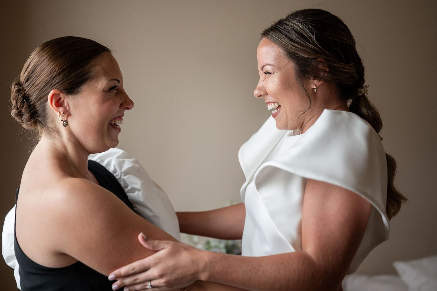 Two dancers in white dresses share an intimate dance moment in soft lighting.