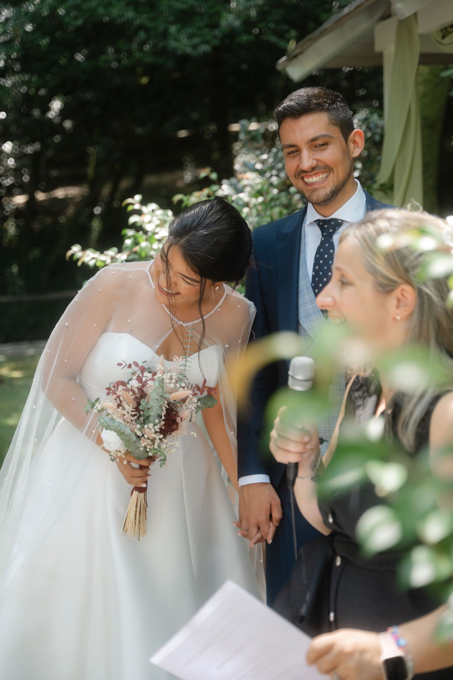 Wedding couple sharing intimate moment during outdoor ceremony with floral decorations.
