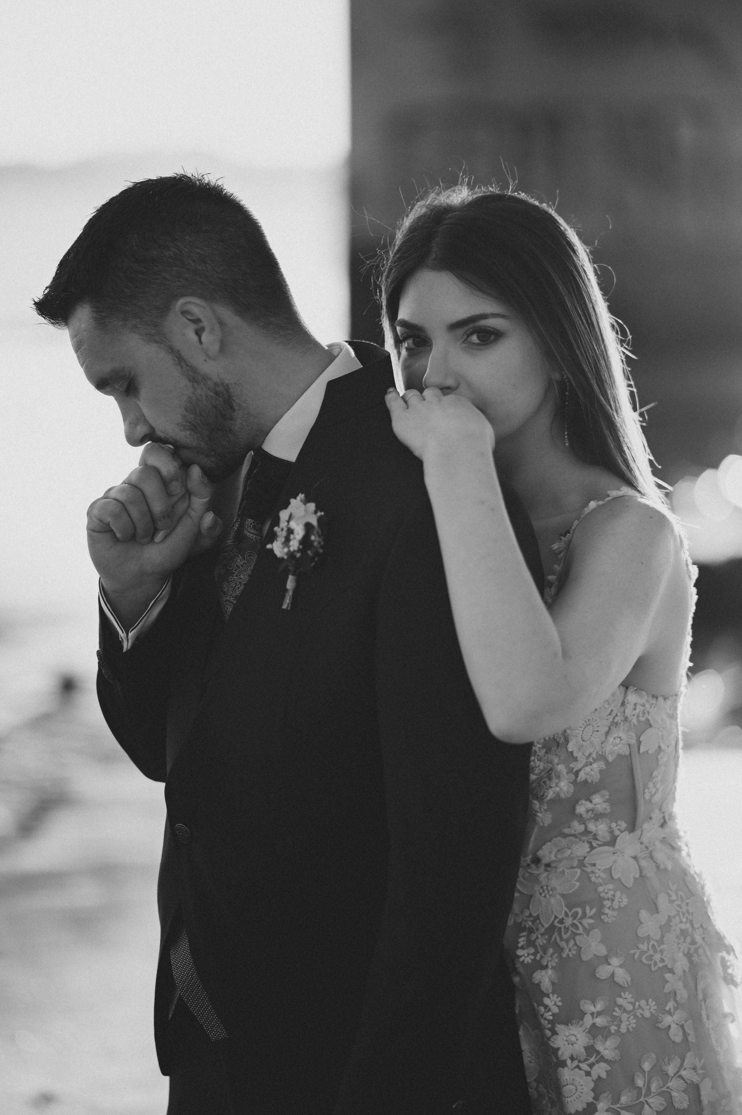 Black and white portrait of a couple in formal attire sharing an emotional moment.