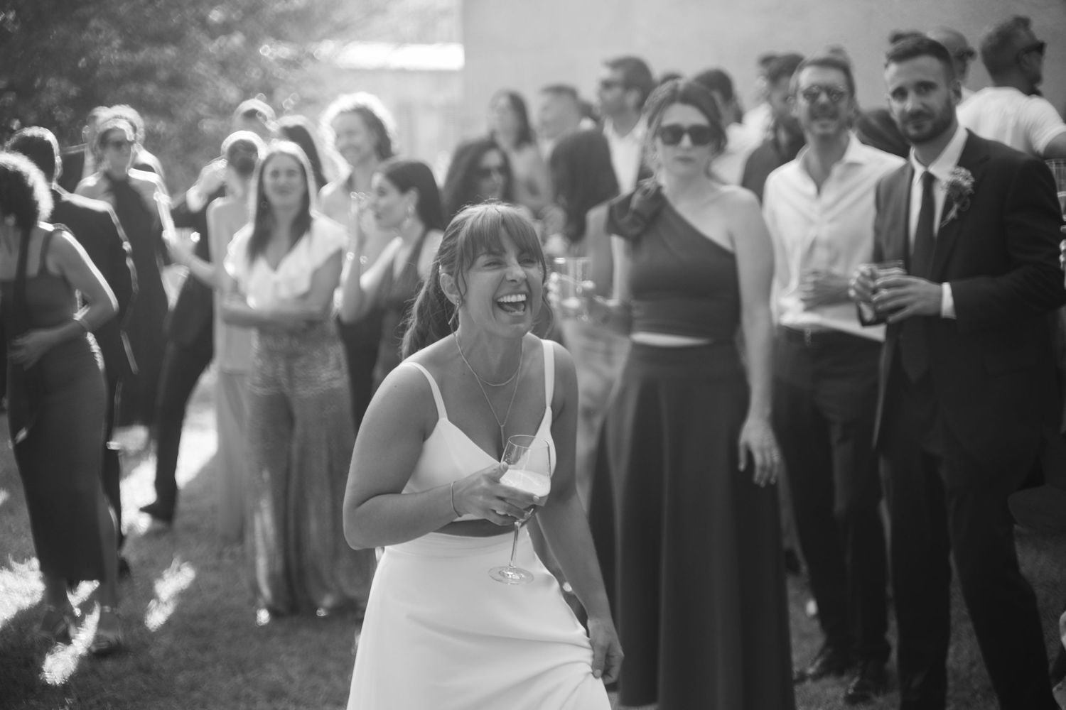 Wedding guests dancing and celebrating at an outdoor reception.