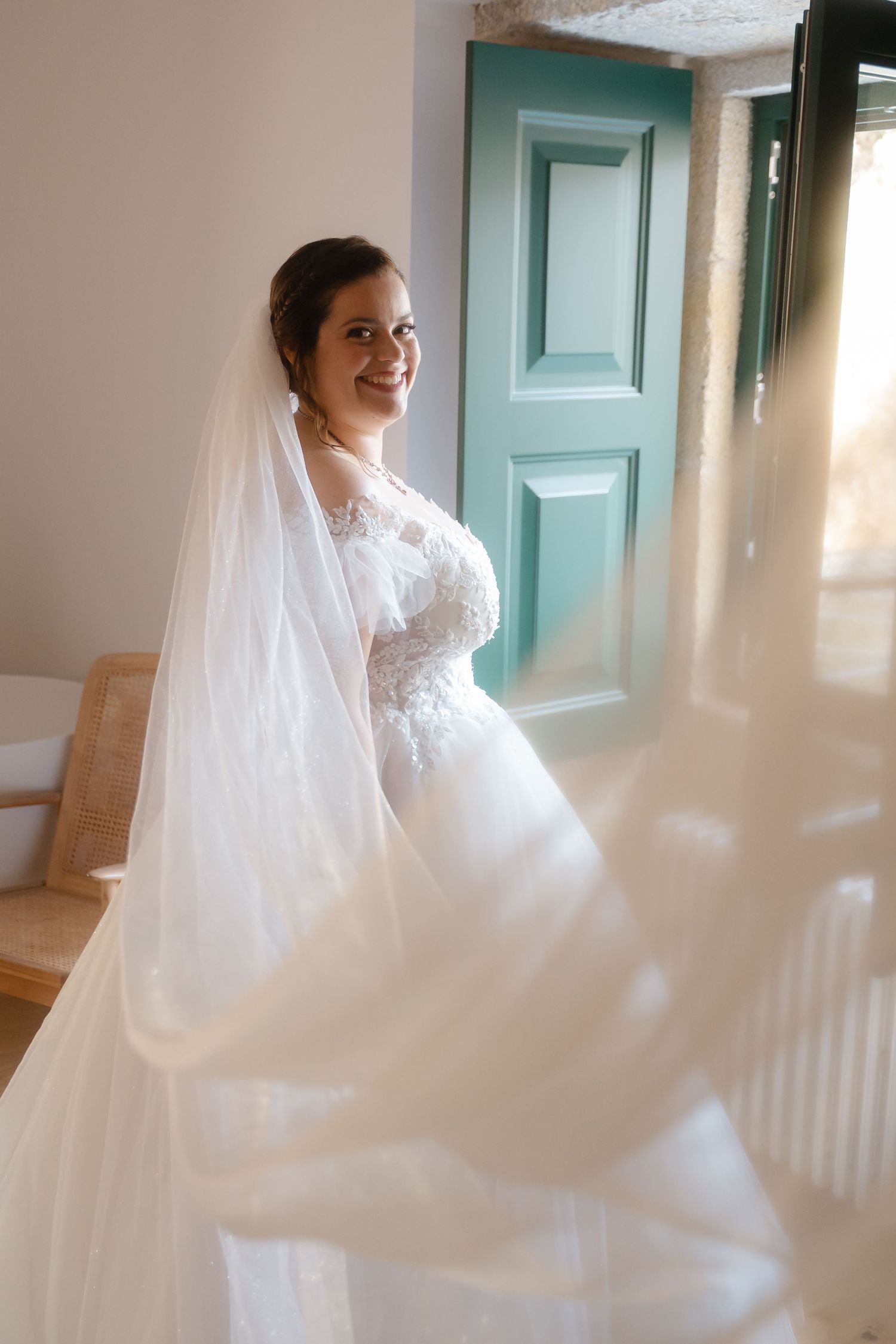 Flowing white wedding veil catches sunlight through windows in an ethereal spinning motion.