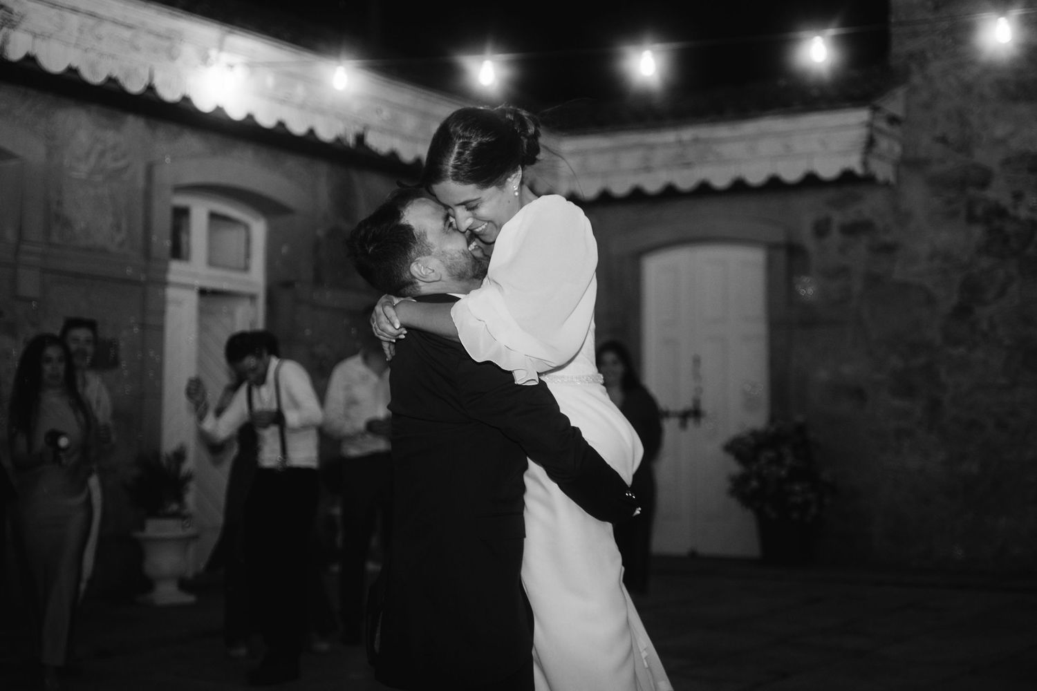 A series of black and white photographs showing people dancing at a wedding reception under dim lighting.