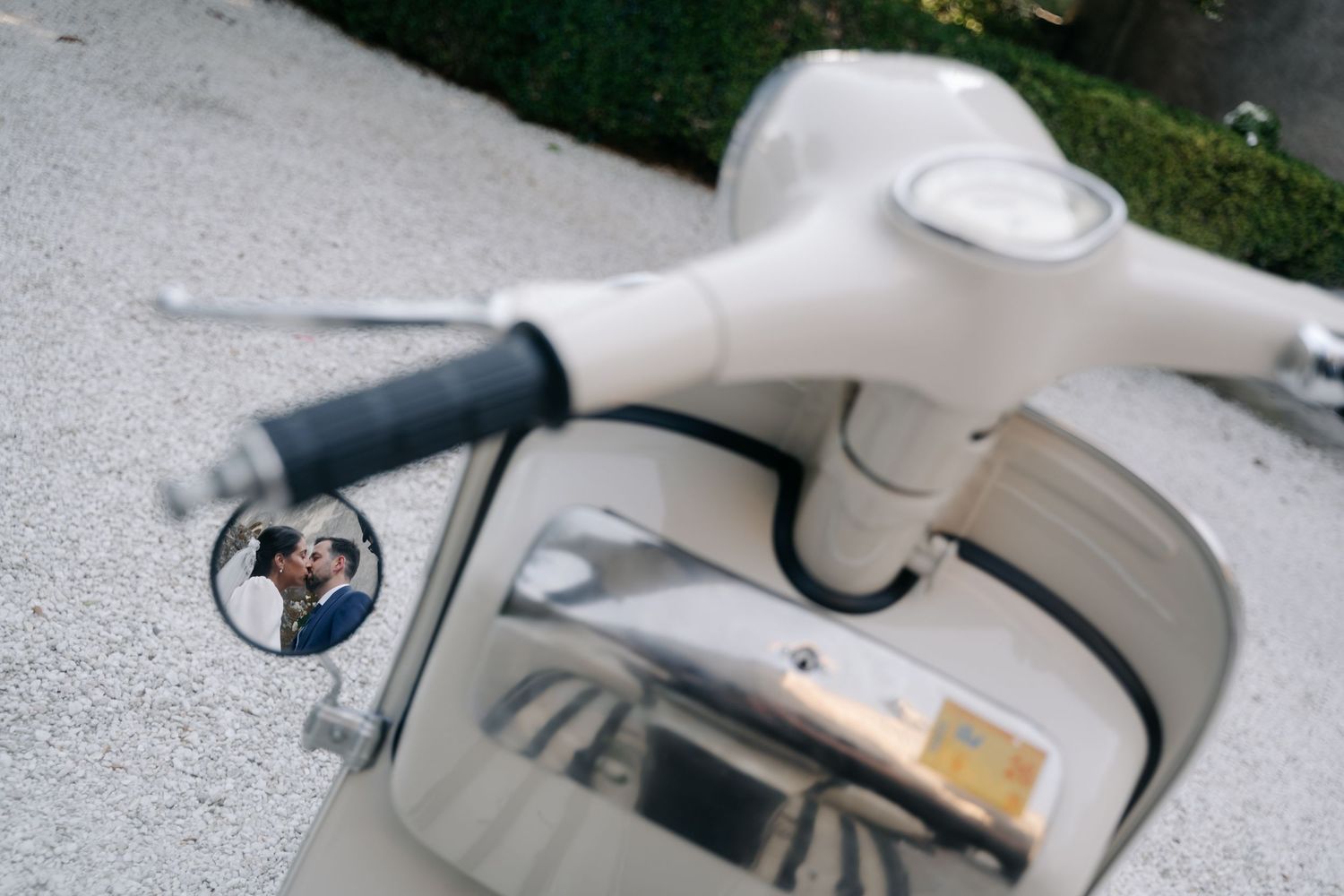 Close-up view of a silver motorcycle's gas tank and handlebar controls showing sleek design details.
