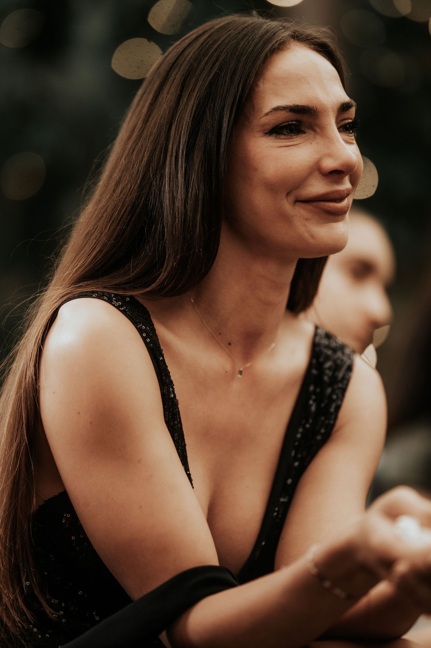 Woman in black dress smiling and laughing during a candid photo session.