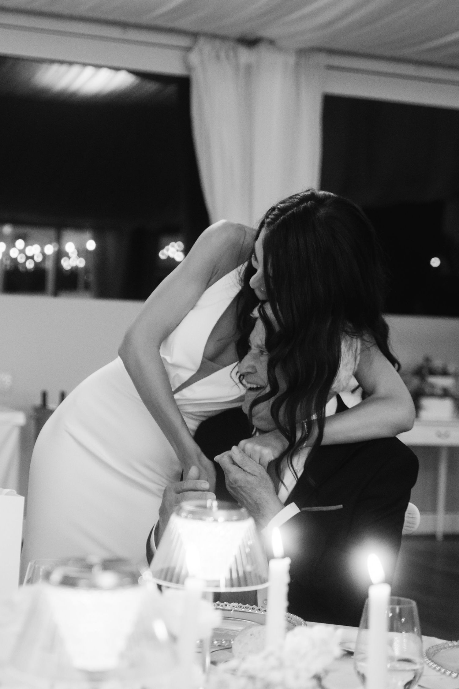 A sequence of black and white photos showing someone blowing out candles on a birthday cake in a dimly lit room.