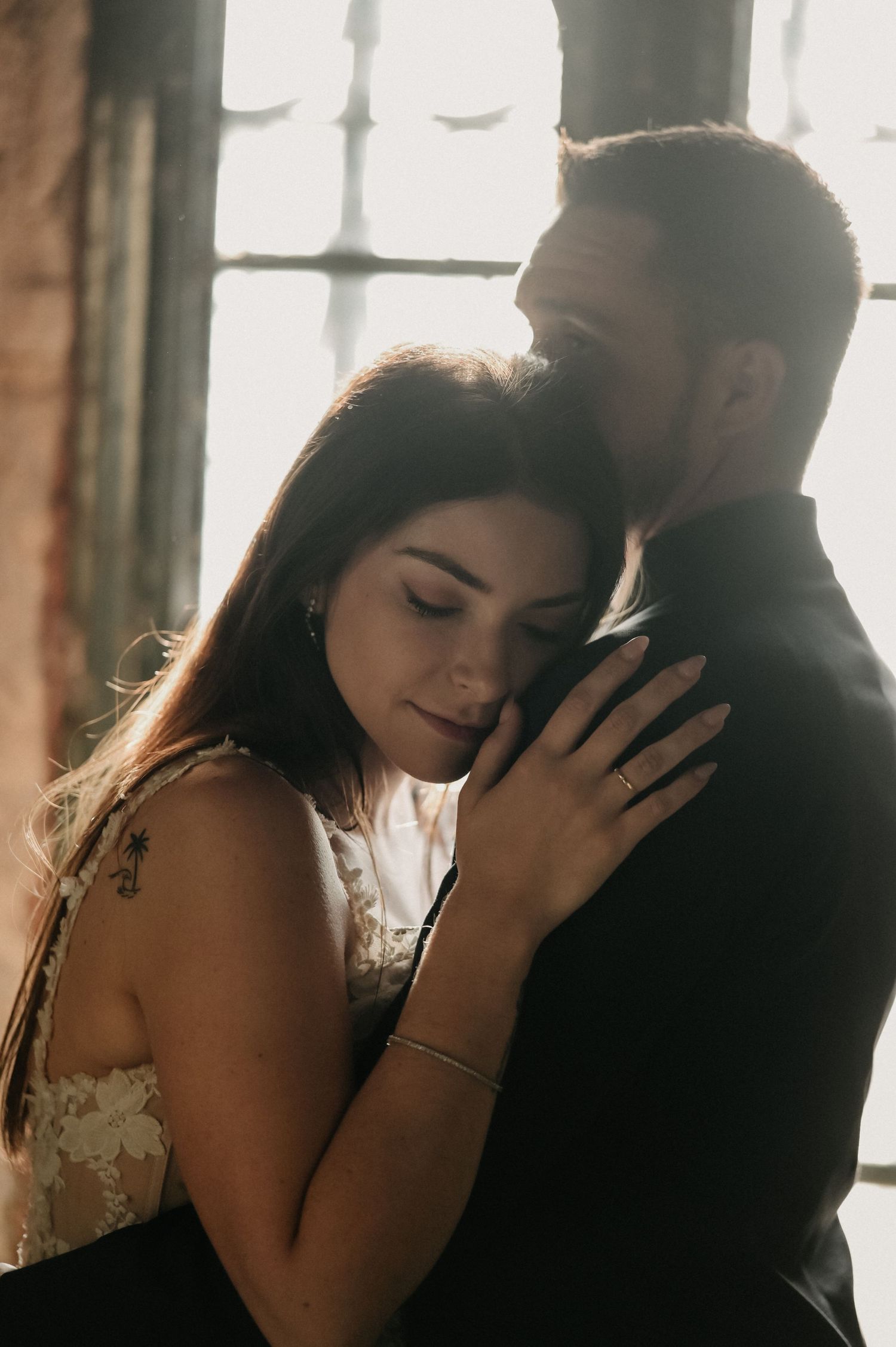 A romantic couple shares an intimate moment in front of a sunlit window in an artistic photo sequence.