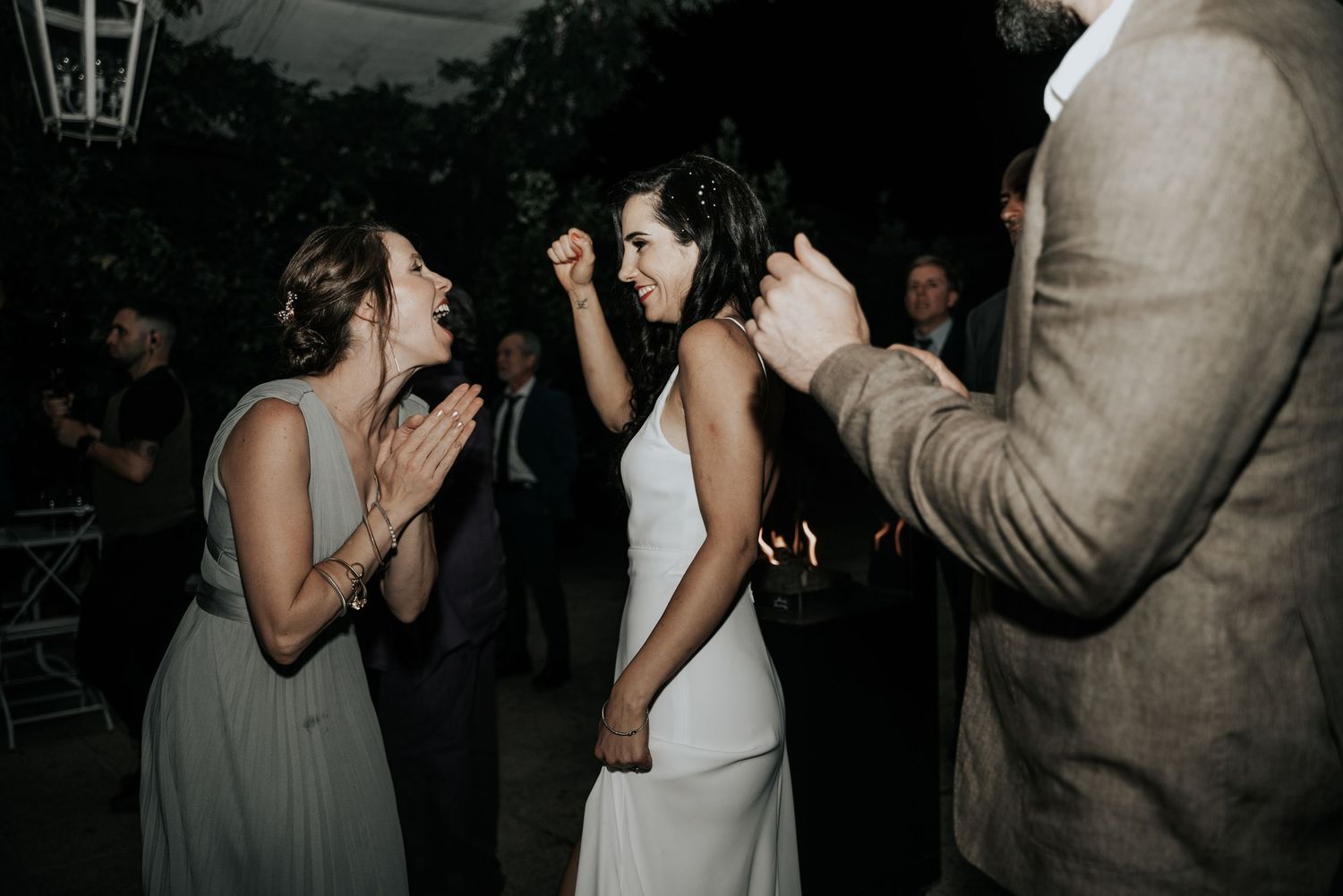 Couples share intimate slow dances at a dimly lit wedding reception venue.