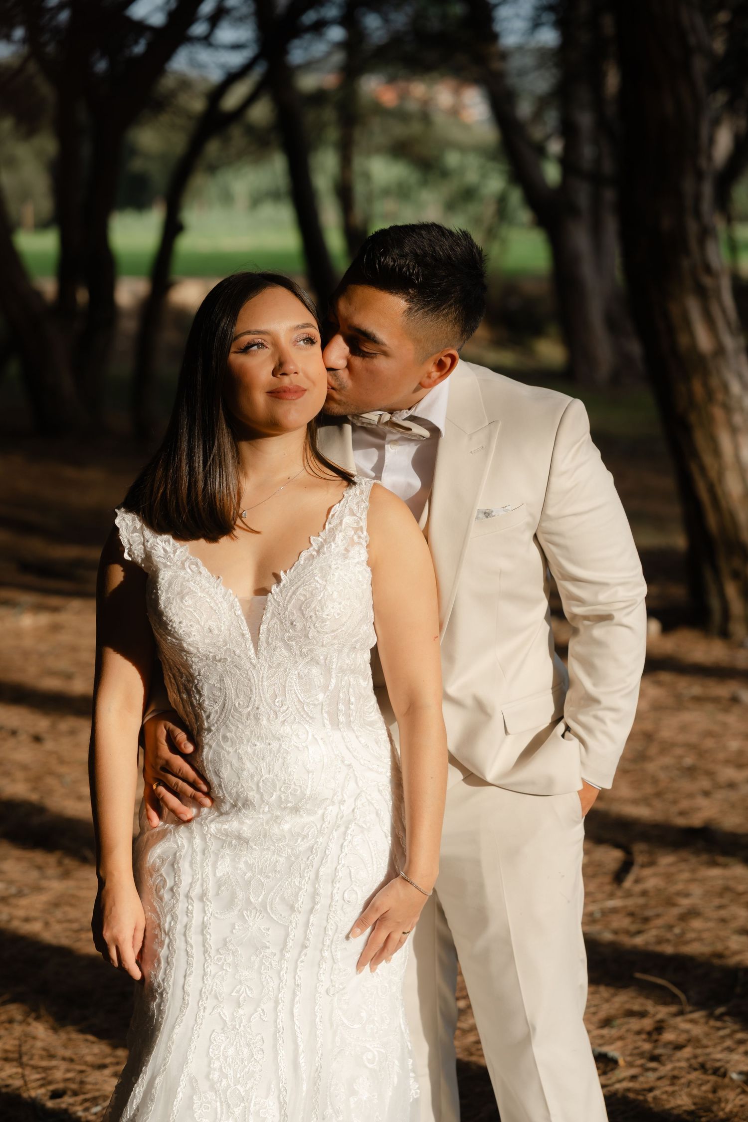 Intimate wedding portraits in a forest setting with couple in white dress and cream suit.