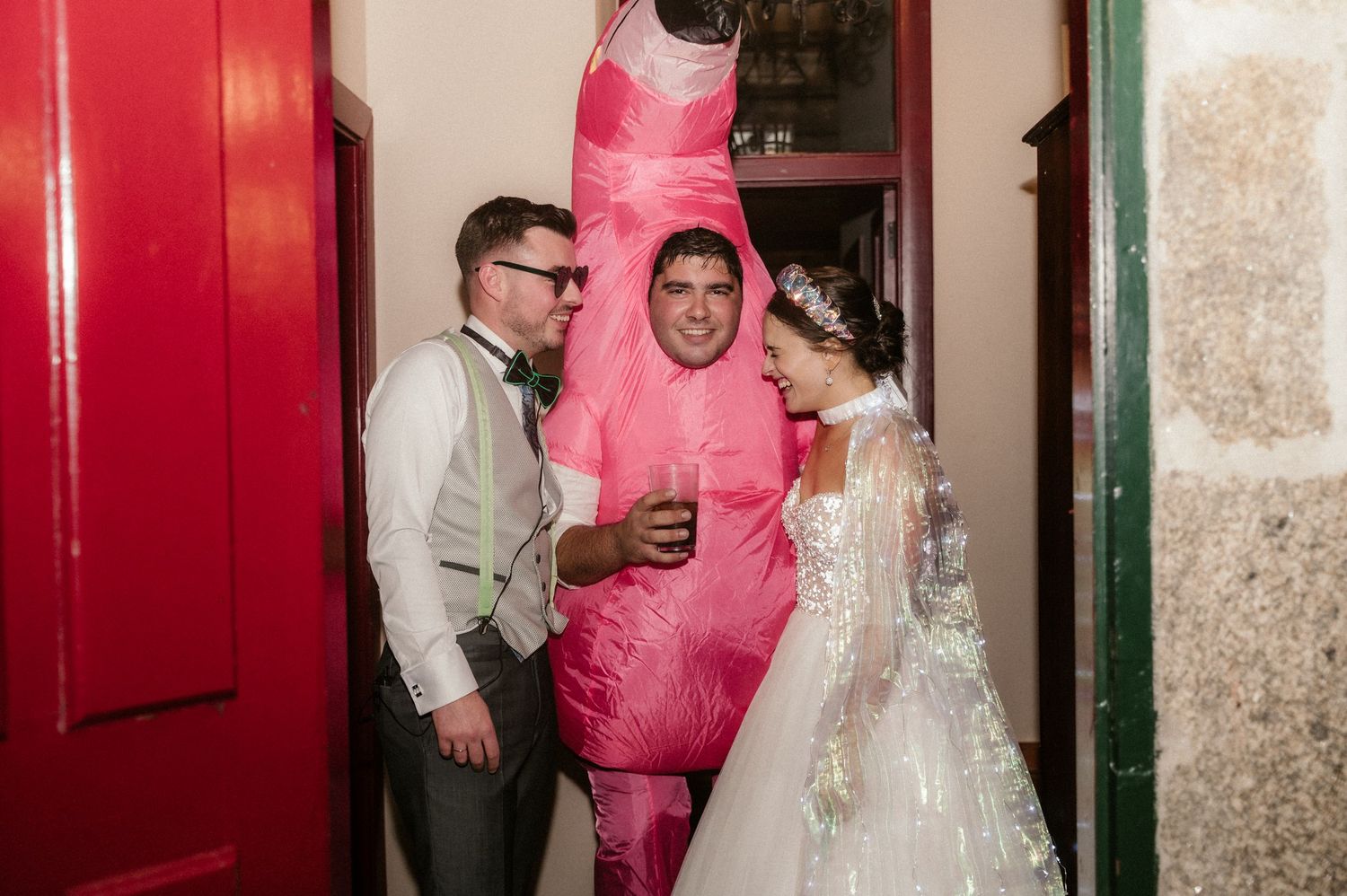 Wedding celebration in a venue with red walls showing guests dancing and enjoying the festivities.